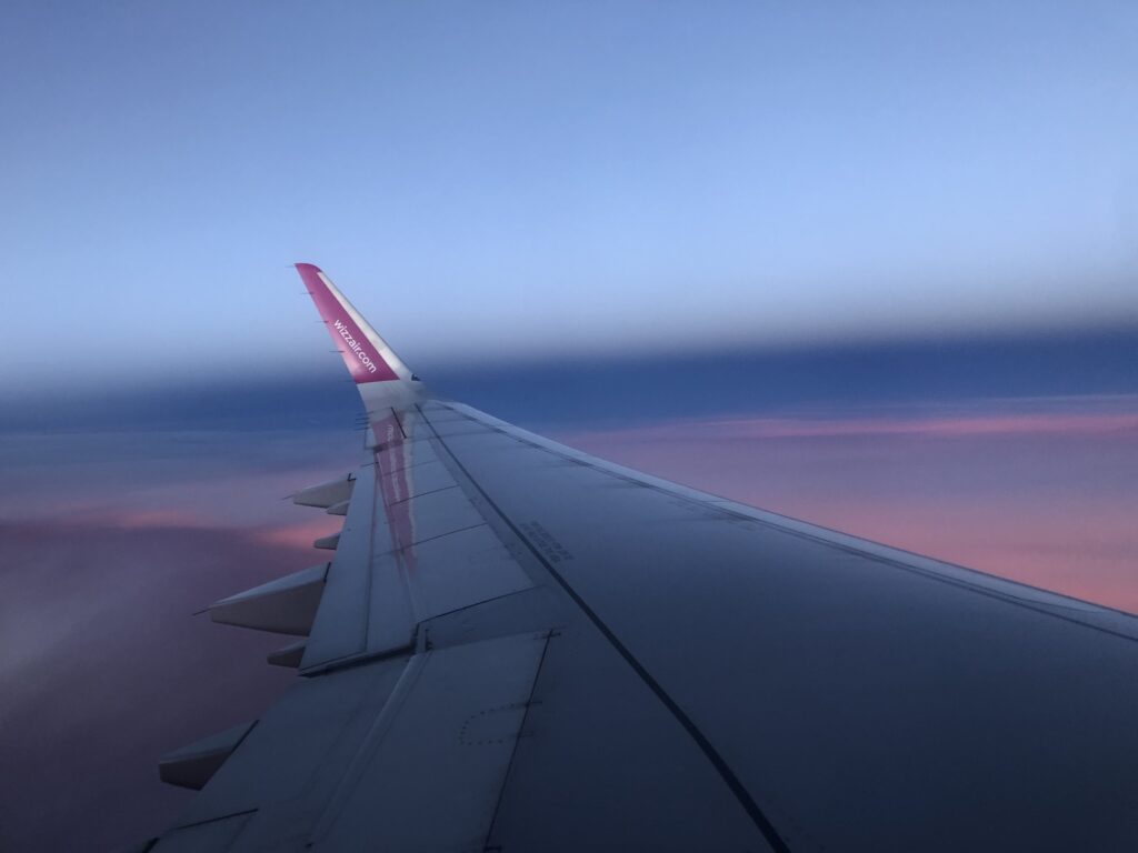 Lot do Albanii, widok z samolotu na różowe niebo. 